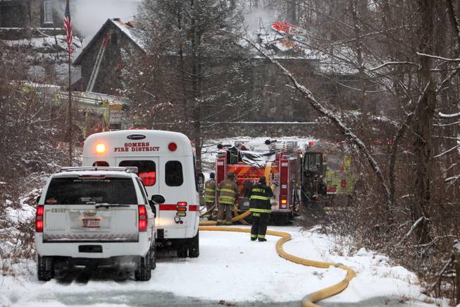 Multiple fire companies battle a blaze in a stone house in Yorktown Heights, N.Y., on Saturday, Dec. 14, 2013. The building belongs to former Kiss guitarist Ace Frehley. 