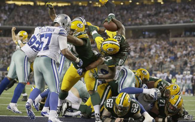 Green Bay Packers running back Eddie Lacy (27) jumps over the line of scrimmage to score a touchdown during the second half of an NFL game against the Dallas Cowboys on Sunday, Dec. 15, 2013, in Arlington, Texas.