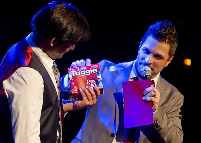Deven May receives a gift from Mark Shunock during "Mondays Dark," a monthly charitable event, at Body English on Monday, Dec. 16, 2013, in the Hard Rock Hotel.