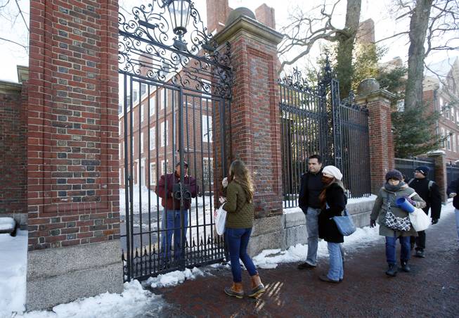 A security officer guards a gate and keeps people from Harvard Yard at Harvard University in Cambridge, Mass., Monday, Dec. 16, 2013. 