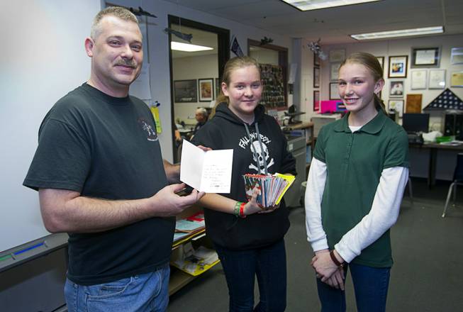 Second Lt. Jay Bergeon, left, Cadet Master Sgt. Emeli Amtman, center, and Cadet Chief Master Sgt. Faith White pose with holiday cards during a civil air patrol meeting at Bridger Middle School in North Las Vegas Tuesday Dec. 17, 2013. The cadets plan to hand out the holiday cards to veterans at the Mike O'Callaghan Federal Hospital at Nellis Air Force Base on Dec. 23.