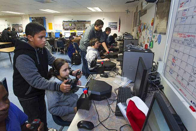 Eighth grader Brian Garcia helps Thalia Santander with a flight simulator during a civil air patrol meeting at Bridger Middle School in North Las Vegas Tuesday Dec. 17, 2013. The cadets plan to hand out the holiday cards to veterans at the Mike O'Callaghan Federal Hospital at Nellis Air Force Base on Dec. 23.