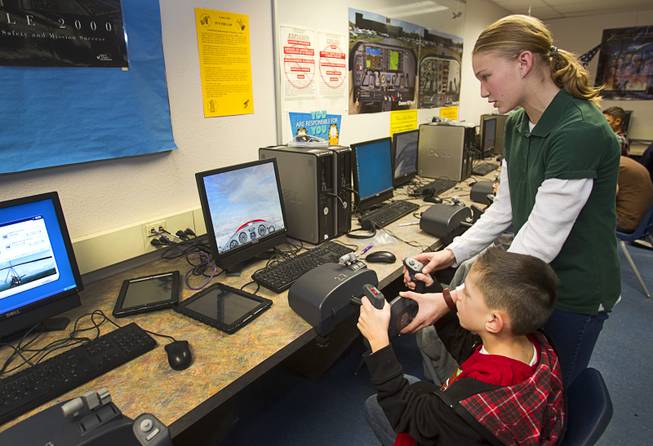 Faith White helps Jake Roszelle operate a flight simulator during a civil air patrol meeting at Bridger Middle School in North Las Vegas Tuesday Dec. 17, 2013. Jake is the founder brother to one of the cadets. The cadets plan to hand out the holiday cards to veterans at the Mike O'Callaghan Federal Hospital at Nellis Air Force Base on Dec. 23.