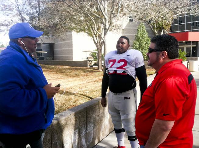 Ron Scoggins Sr., left, talks with his son, Ron Scoggins Jr., right, after UNLV football practice December 17, 2013. When the Rebels play Jan. 1 in the Heart of Dallas bowl, they will become the program's first father-son to play in the postseason. Scoggins Sr. was part of the 1984 California Bowl championship team.
