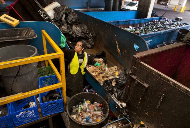 Flor Amador sorts through the refuse on the Caesars Palace loading dock as they sort out certain materials for recycling and reuse Tuesday, Dec. 17, 2013.