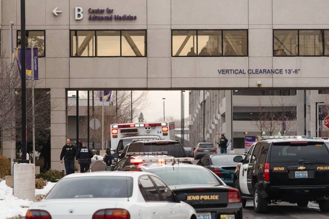Officers gather in front of the Renown Regional Medical Center after a lone gunman shot and injured four people before killing himself , Tuesday, Dec. 17, 2013 in Reno, Nev.