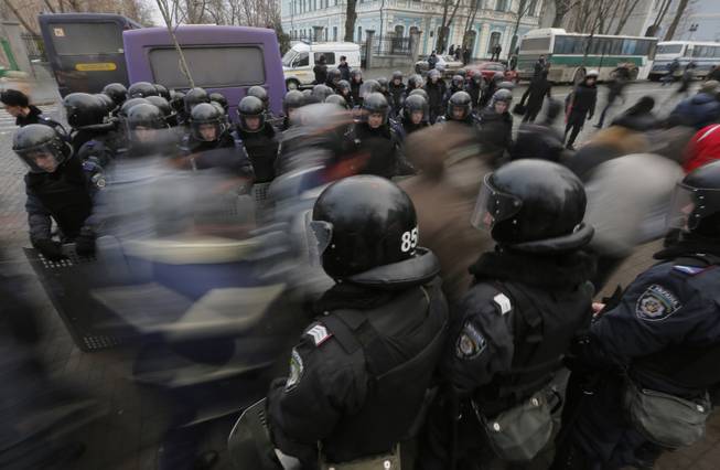 Pro-European Union activists pass through a police line as they march against the government in Kiev, Ukraine, Tuesday, Dec. 17, 2013. Weeks of angry pro-European Union protests as well as Western pressure have forced Yanukoyvch to make some concessions to the opposition. Last week Yanukovych called for an amnesty for some of the activists detained. 