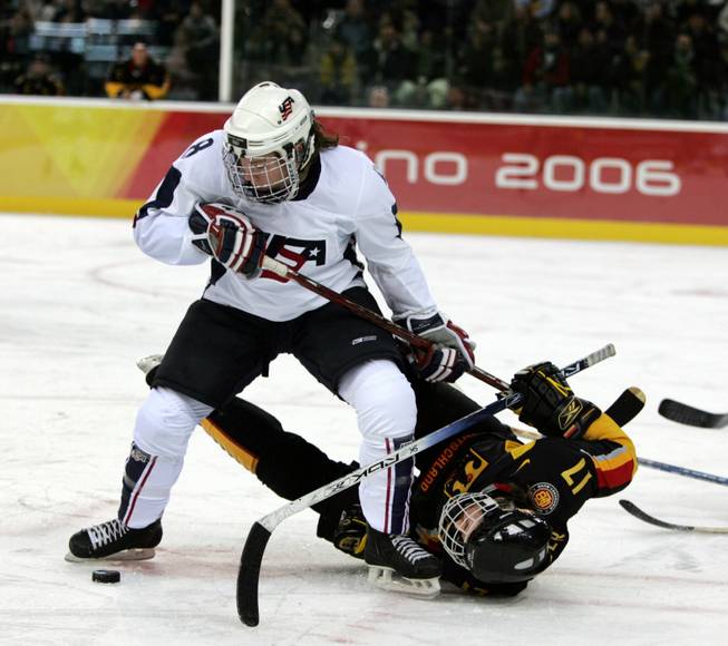 In this Feb. 12, 2006, file photo, the United States' Caitlin Cahow (8) upends Germany's Sara Seiler during the first period of a 2006 Winter Olympics ice hockey match in Turin, Italy. Cahow will join Deputy Secretary of State Bill Burns at the closing ceremony delegation of the Winter Olympics next year in Sochi, Russia.