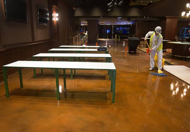 A worker cleans by beer pong tables during a hard hat tour of the new O'Sheas casino Tuesday Dec. 18, 2013. The casino is scheduled to open Dec. 27.