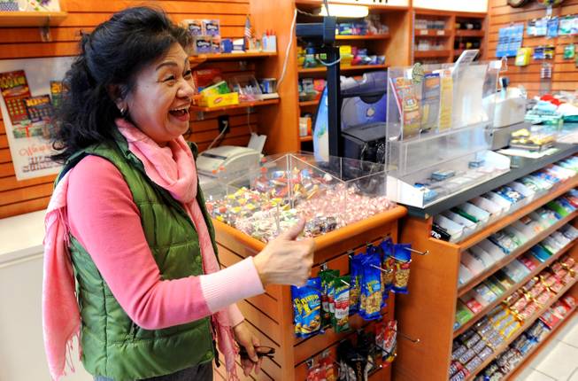 Owner Young Soo Lee basks in the attention at her small Alliance Center office building newsstand on Wednesday, Dec. 18, 2013, in Atlanta, after lottery officials said one of two winning Mega Millions lottery tickets were purchased from her store in Tuesday's $636 million drawing. The store owner said she sold 1,300 lottery tickets on Tuesday rather than the normal sales of about 100 tickets.