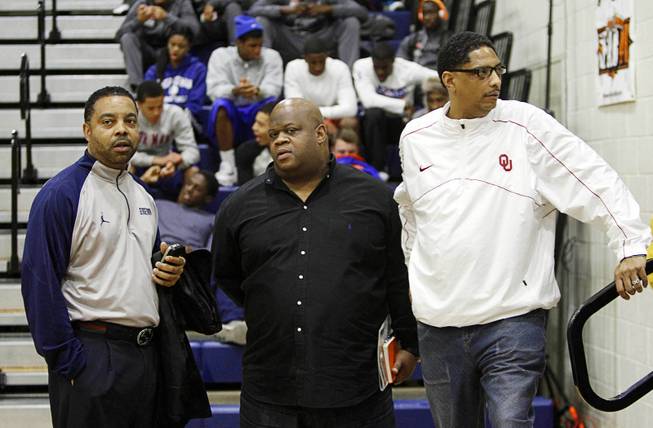 Georgetown's Kevin Broadus, left, Nike Basketball scout Vince Baldwin, and Lew Hill of the University of Oklahoma watch Clark High School take on national powerhouse Mater Dei High School (Santa Ana, Calif.) during the Tarkanian Classic at Bishop Gorman High School Thursday, Dec. 19, 2013.