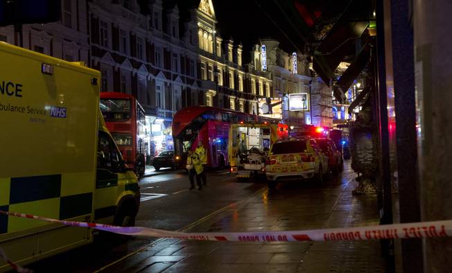 Emergency service vehicles gathered among London buses  following an incident  during a performance at the Apollo Theatre, far right, in London's Shaftesbury Avenue, Thursday evening, Dec. 19, 2013. It wasn't immediately clear if the roof, ceiling or balcony had collapsed. 