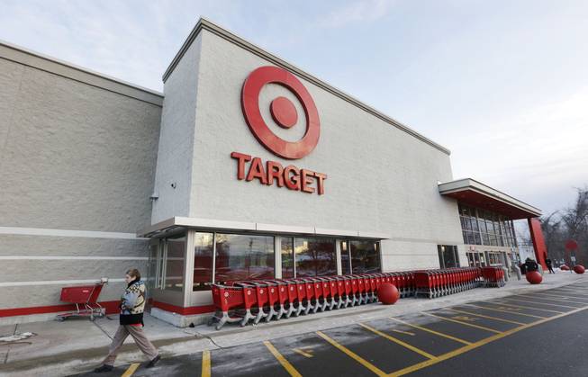 A passer-by walks near an entrance to a Target retail store Thursday, Dec. 19, 2013, in Watertown, Mass. Target says that about 40 million credit and debit card accounts may have been affected by a data breach that occurred just as the holiday shopping season shifted into high gear.