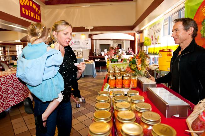While shopping with her daughter, Clairin DeMartini describes the flavor of the sweet and spicy beets sampled in Nick Kreway's The Pickled Pantry booth at the Downtown Farmers' Market in Las Vegas Friday, December 20, 2013.