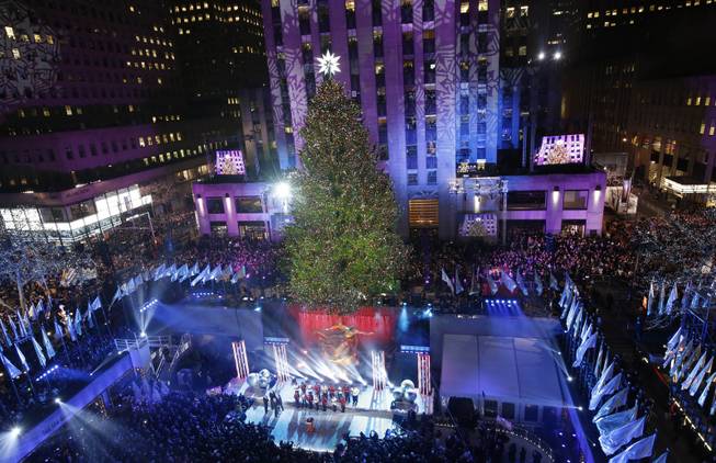 The Rockefeller Center Christmas tree is lit during a ceremony, Wednesday, Dec. 4, 2013, in New York. Some 45,000 energy efficient LED lights adorn the 76-foot tree.