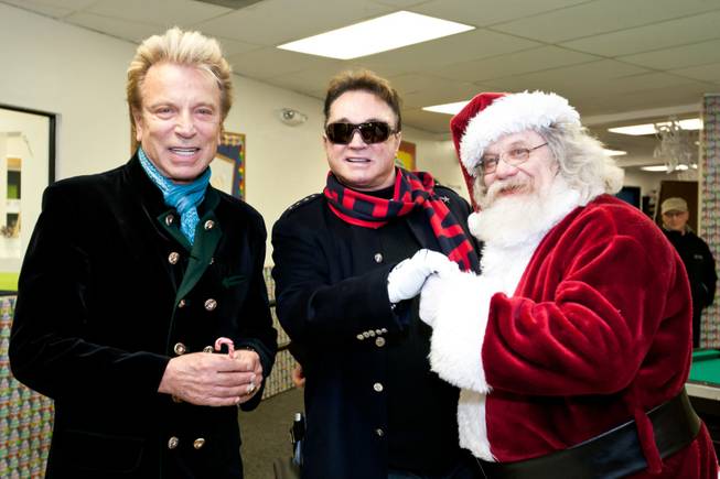 Siegfried and Roy receive some Santa cheer for their goodwill during the holiday party at the Boys and Girls Club at 2801 E. Stewart Avenue in Las Vegas December 20, 2013.