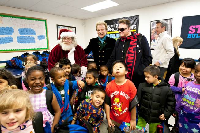 Children gather around Siegfried and Roy after receiving their backpacks full of gifts provided by Siegfried and Roy during the holiday party at the Boys and Girls Club at 2801 E. Stewart Avenue in Las Vegas December 20, 2013.