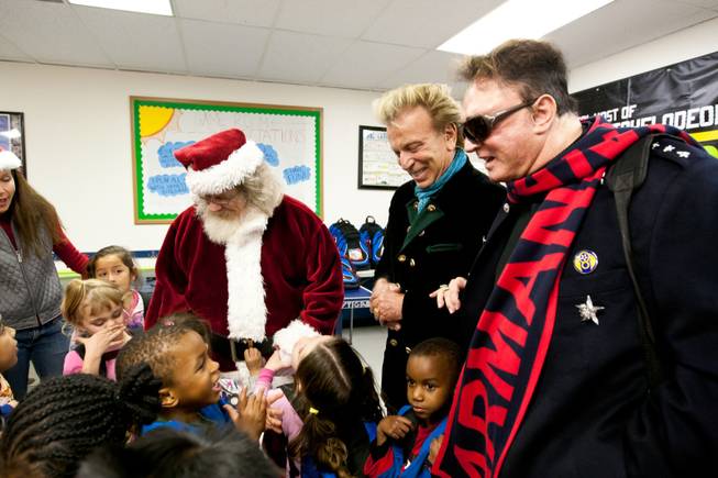 Siegfried and Roy laugh as a young boy makes tiger sounds for them during the holiday party at the Boys and Girls Club at 2801 E. Stewart Avenue in Las Vegas December 20, 2013.