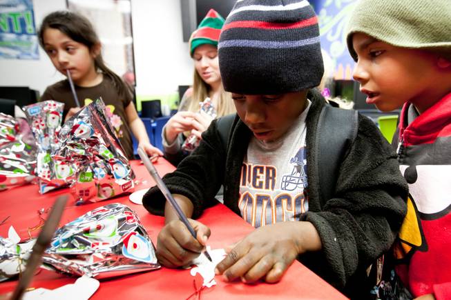 Kenneth Williams, 5, concentrates as his friend, Isaias Franco, 6, reads the note he's making for his mom's gift during the holiday party at the Boys and Girls Club at 2801 E. Stewart Avenue in Las Vegas December 20, 2013.