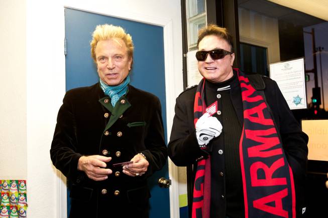 Upon their arrival, Siegfried and Roy are given honorary Boys and Girls Club membership cards holiday party at the Boys and Girls Club at 2801 E. Stewart Avenue in Las Vegas December 20, 2013.