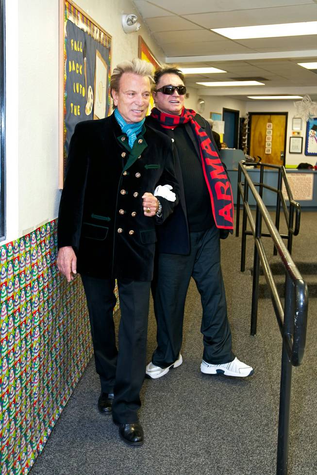Siegfried and Roy make their way into the recreation room to greet the children at the holiday party at the Boys and Girls Club at 2801 E. Stewart Avenue in Las Vegas December 20, 2013.
