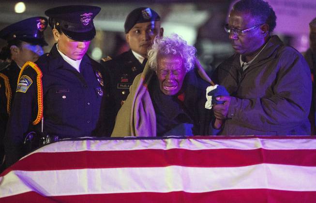 Clara Gantt, the 94-year-old widow of U.S. Army Sgt. Joseph Gantt, weeps in front of her her husband's casket after it was lowered from the plane, Friday, Dec. 20, 2013 in Los Angeles. Sixty-three years after Army Sgt. 1st Class Joseph E. Gantt went missing in action during the Korean War, his remains were returned to his 94-year-old widow in a solemn ceremony at Los Angeles International Airport before dawn Friday.