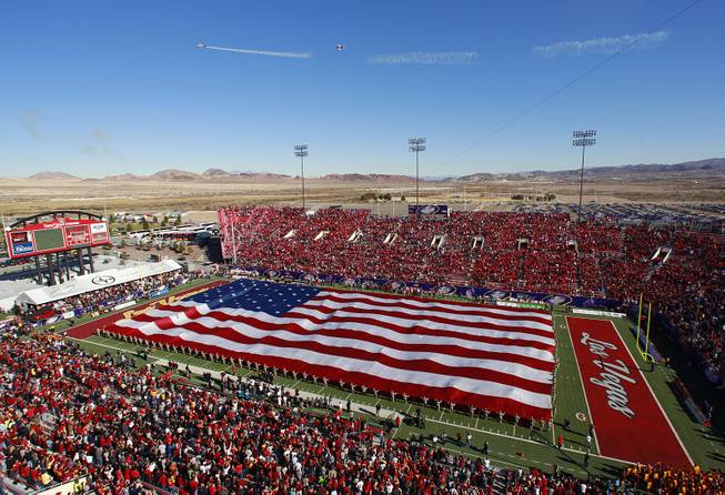 Jets fly overhead and a U.S. flag is stretched over the field during pre game ceremonies before the Royal Purple Las Vegas Bowl between USC and Fresno State Saturday, Dec. 21, 2013 at Sam Boyd Stadium. USC won the game 45-20.