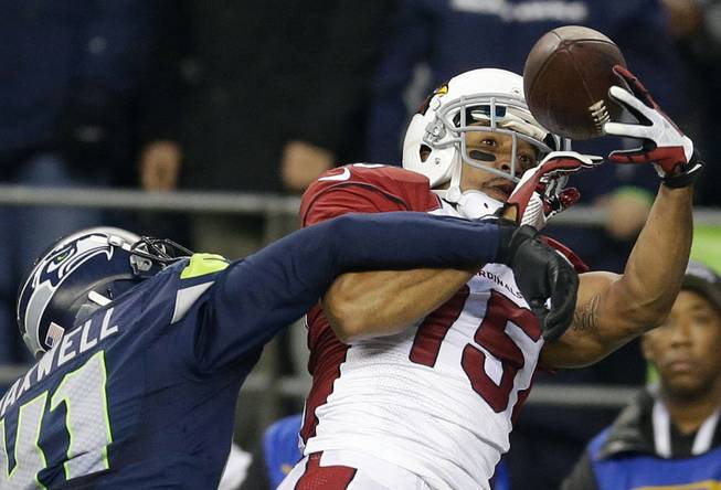 Arizona Cardinals wide receiver Michael Floyd makes a catch for a touchdown despite the defense of Seattle Seahawks cornerback Byron Maxwell in the second half of an NFL football game Sunday, Dec. 22, 2013, in Seattle.