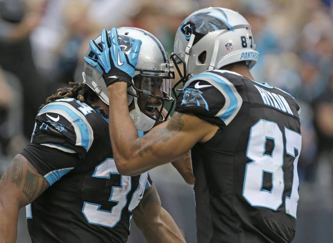 Carolina Panthers' DeAngelo Williams, left, is congratulated by teammate Domenik Hixon after Williams' touchdown run against the New Orleans Saints in the first half of an NFL football game in Charlotte, N.C., on Sunday, Dec. 22, 2013.