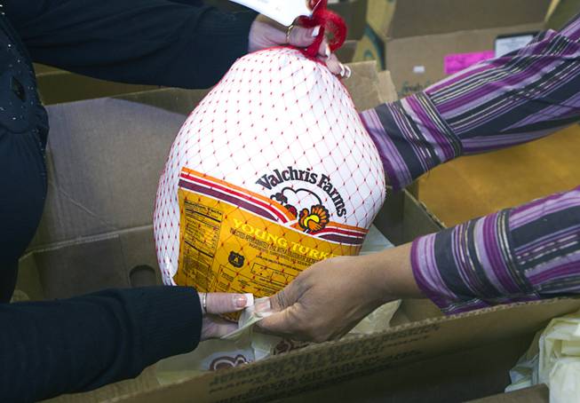 Arizona Charlie's employees pack a turkey into a holiday food box at the Boulder Highway location Monday, Dec. 23, 2013. Casino patrons contributed loyalty card points to the Feed a Family program and bought holiday dinners for 60 families. The food baskets will be picked up by the Southern Nevada Regional Housing Authority for distribution to needy families. Each food box feeds a family of four and includes a turkey, stuffing, potatoes, gravy, vegetables, cranberry sauce, dinner rolls and pumpkin pie.