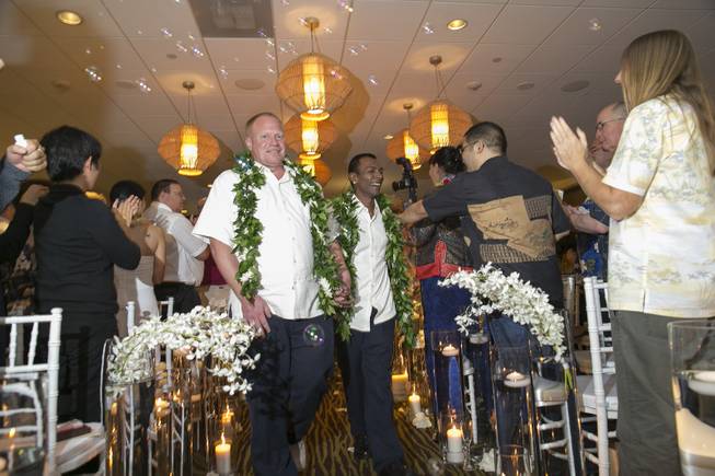 In this Monday, Dec. 2, 2013 file photo, Shaun Campbell, left, and Tony Singh are congratulated by guests after their wedding at the Sheraton Waikiki in Honolulu. Hawaii became the 15th state to legalize same-sex marriage. 