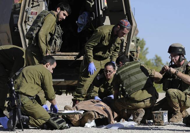 Israeli army paramedics treat a civilian shot near the Israel and Gaza border, Tuesday, Dec. 24, 2013. The man, an Israeli civilian, was shot as he performed maintenance work on the border fence and pronounced dead on arrival to a hospital.