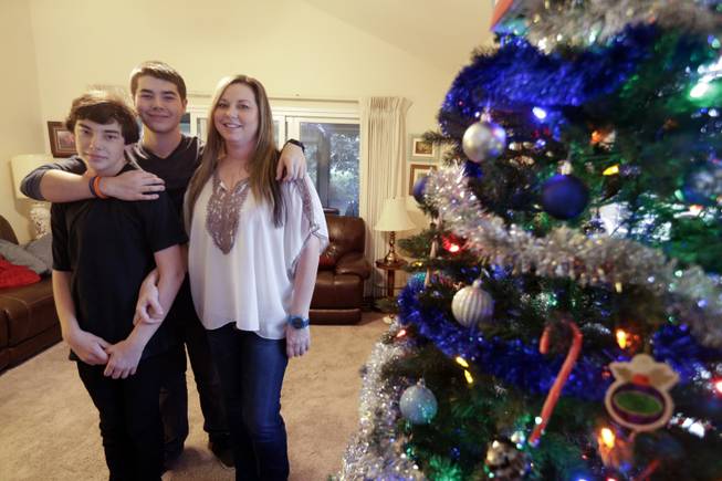 From left, brothers Trevin Kremis and Matthew Kremis pose for a picture with their mother, Deanna Kremis, in their home in San Marcos, Calif. All three have received heart transplants, after suffering with an inherited heart condition.