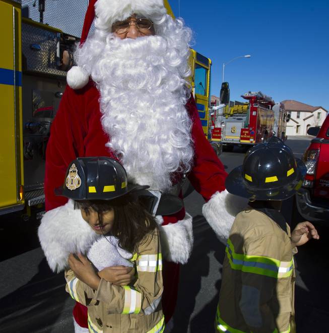 Lupita Cambero, 10, and brother Isaac, 8, hang out with Santa on Christmas morning who brought presents from Operation FireH.E.A.T. (Holiday Emergency Assistance Team) on Wednesday, Dec. 25, 2013.