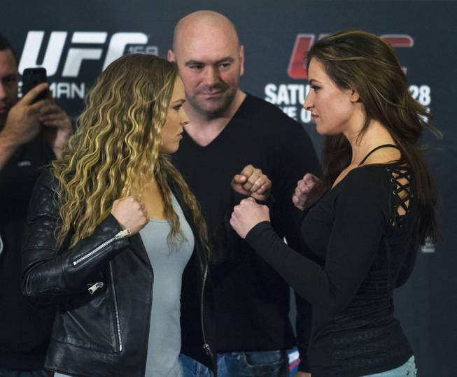 Ronda Rousey and Miesha Tate face off between Dana White near the end of a press conference for the upcoming UFC168 at the MGM Grand Hotel & Casino with commentary from the top fighters on the card Thursday,  Dec. 26, 2013.