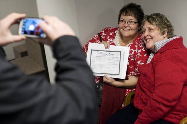 In this Thursday, Dec. 26, 2013, file photo, Cheryl Haws, right, and her partner Shelly Eyre have their photograph taken after receiving their marriage license at the Utah County Clerk's office in Provo, Utah. 