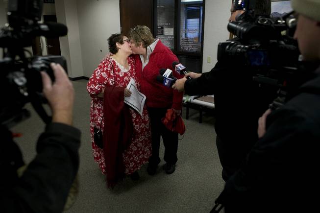 In this Thursday, Dec. 26, 2013, file photo, Shelly Eyre, left, kisses her partner Cheryl Haws while being interviewed by the media after their marriage license was issued at the Utah County Clerk's office in Provo, Utah. 