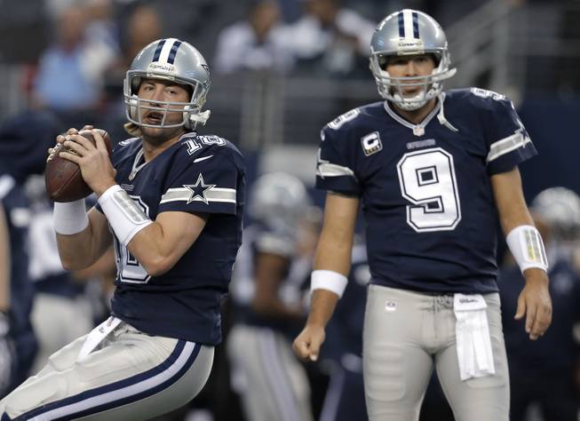 In this Nov. 28, 2013, photo, Dallas Cowboys quarterbacks Kyle Orton (18) and Tony Romo (9) warm up for an NFL football game against the Oakland Raiders in Arlington, Texas. Orton will make his first start at quarterback in his two seasons with the Cowboys on Sunday night, Dec. 29, unless Romo can recover from a herniated disc. Dallas will be playing a winner-take-all game at home against the Philadelphia Eagles for the NFC East title and a playoff berth.
