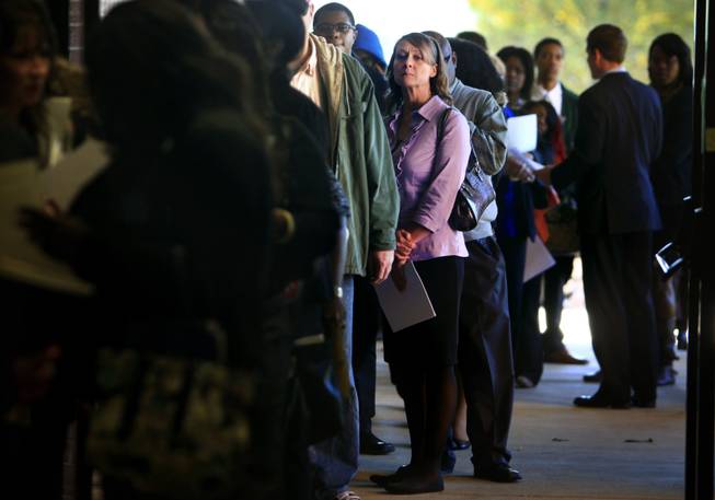 In this Nov. 7, 2013, photo, Jona Caldwell joins a long line of job seekers outside Ferguson Community Center in Cordova, Tenn.