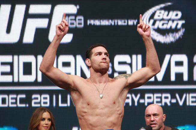 Champion Chris Weidman points up after making weight during the weigh in for UFC 168 Friday, Dec. 27, 2013 at the MGM Grand Garden Arena.