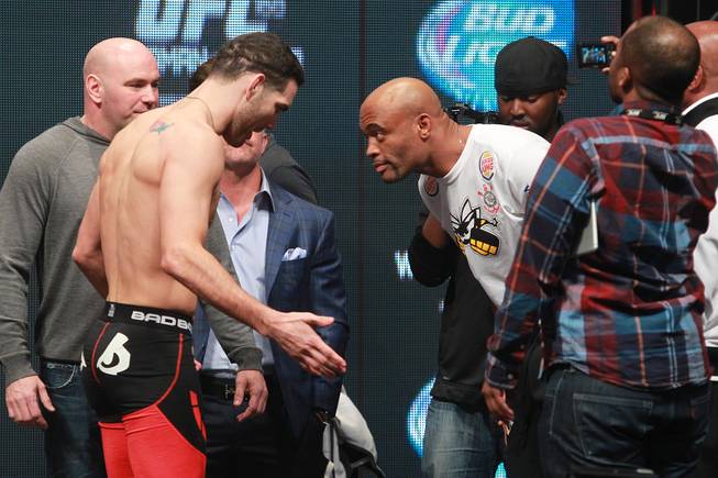 Champion Chris Weidman and former champion Anderson Silva bow after facing off during the weigh in for UFC 168 Friday, Dec. 27, 2013 at the MGM Grand Garden Arena.