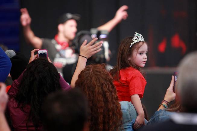 A young girl is distracted as champion Chris Weidman makes his entrance during the weigh in for UFC 168 Friday, Dec. 27, 2013 at the MGM Grand Garden Arena.