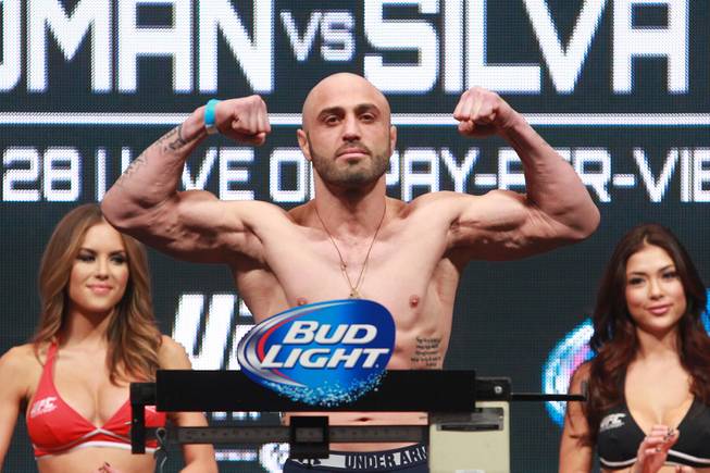 Manvel Gamburyan flexes after making weight during the weigh in for UFC 168 Friday, Dec. 27, 2013 at the MGM Grand Garden Arena.