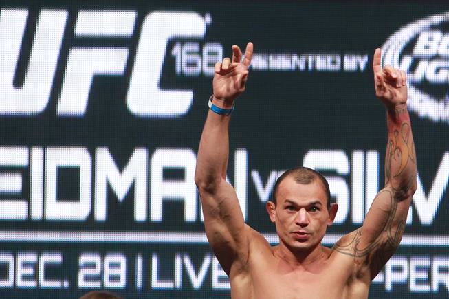 Gleisen Tibau raises his arms after making weight during the weigh in for UFC 168 Friday, Dec. 27, 2013 at the MGM Grand Garden Arena.