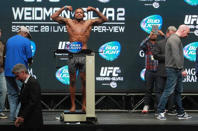 Michael Johnson raises his arms during the weigh in for UFC 168 Friday, Dec. 27, 2013 at the MGM Grand Garden Arena.