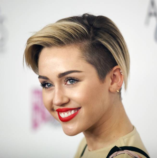Miley Cyrus arrives at the red carpet for the grand opening of Britney Spears’ “Britney: Piece of Me” at Planet Hollywood on Friday, Dec. 27, 2013, in Las Vegas.