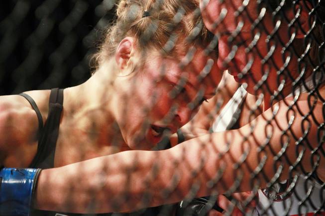 Ronda Rousey forces Miesha Tate to the fence during their fight at UFC 168 Saturday, Dec. 28, 2013 at the MGM Grand Garden Arena.