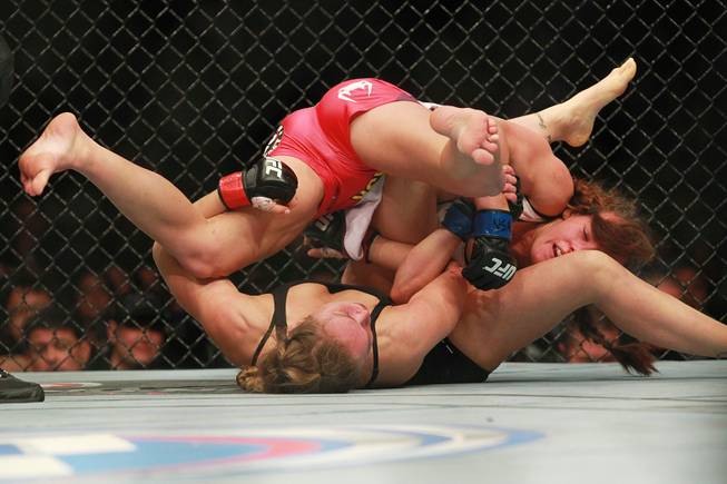 Miesha Tate spins over the top of Ronda Rousey during their fight at UFC 168 Saturday, Dec. 28, 2013 at the MGM Grand Garden Arena.