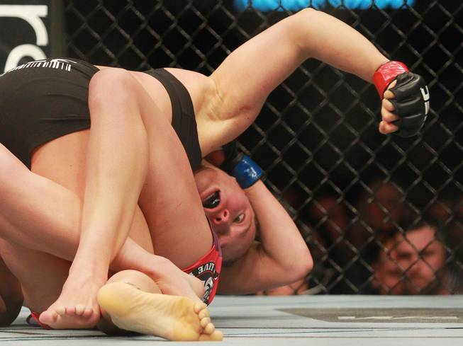 Ronday Rousey looks for a body shot on Misha Tate during their fight at UFC 168 Saturday, Dec. 28, 2013 at the MGM Grand Garden Arena.