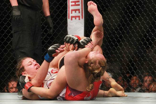 Miesha Tate tries to choke Ronda Rousey with her legs during their fight at UFC 168 Saturday, Dec. 28, 2013 at the MGM Grand Garden Arena.